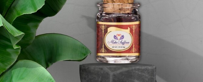 Premium all-red saffron in a glass jar on a black stone pedestal with green tropical leaves, highlighting its rich color, quality, and royal heritage for gourmet culinary use.