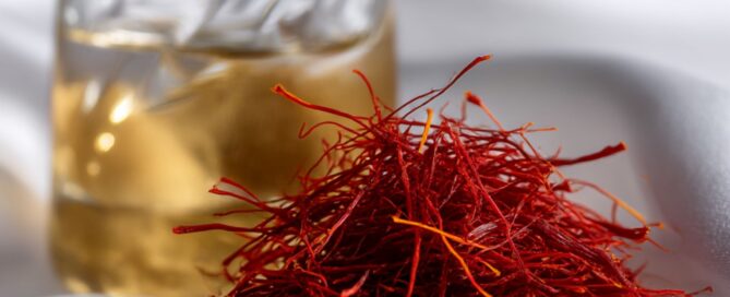 Premium all-red saffron threads and saffron-infused golden oil in a clear glass jar, showcasing the luxury of Mehr Saffron.